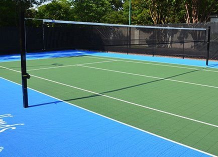 Outdoor volleyball court with synthetic flooring and net installation