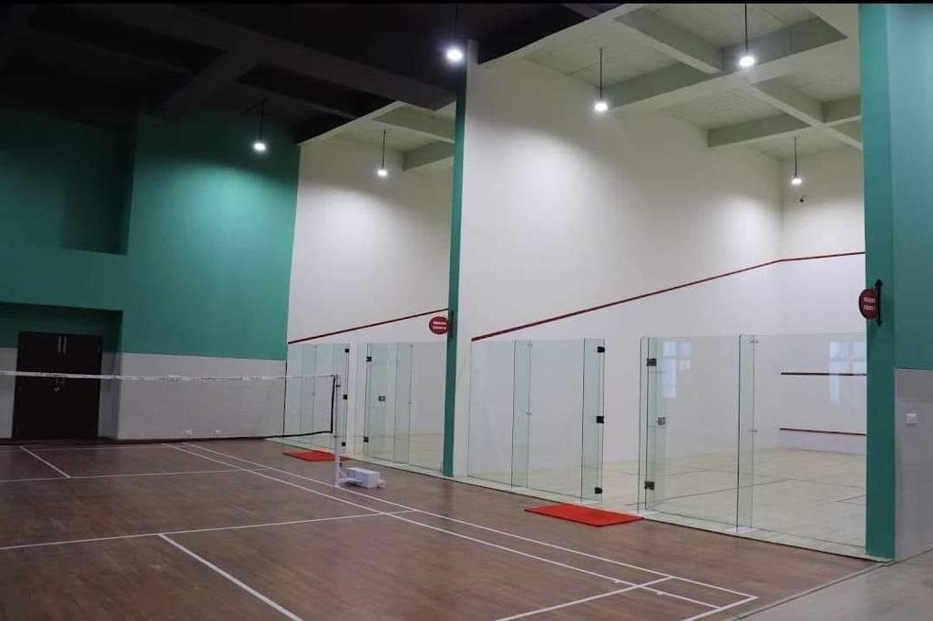 Modern indoor squash court with glass walls and professional lighting