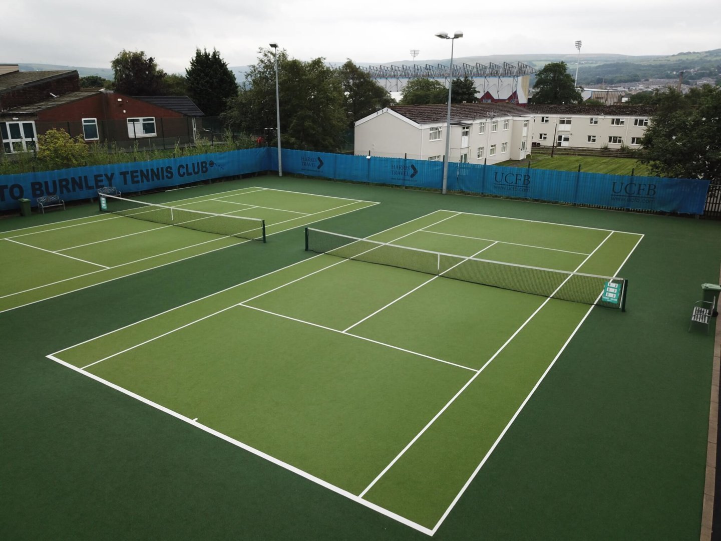 Outdoor tennis court with green synthetic surface and clear line markings