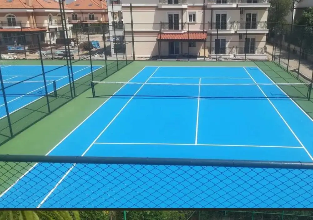 Outdoor tennis court with synthetic flooring and professional net setup