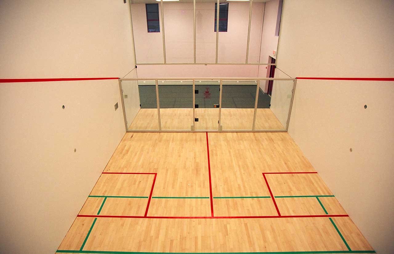 Professional indoor squash court with wooden floor and standard markings