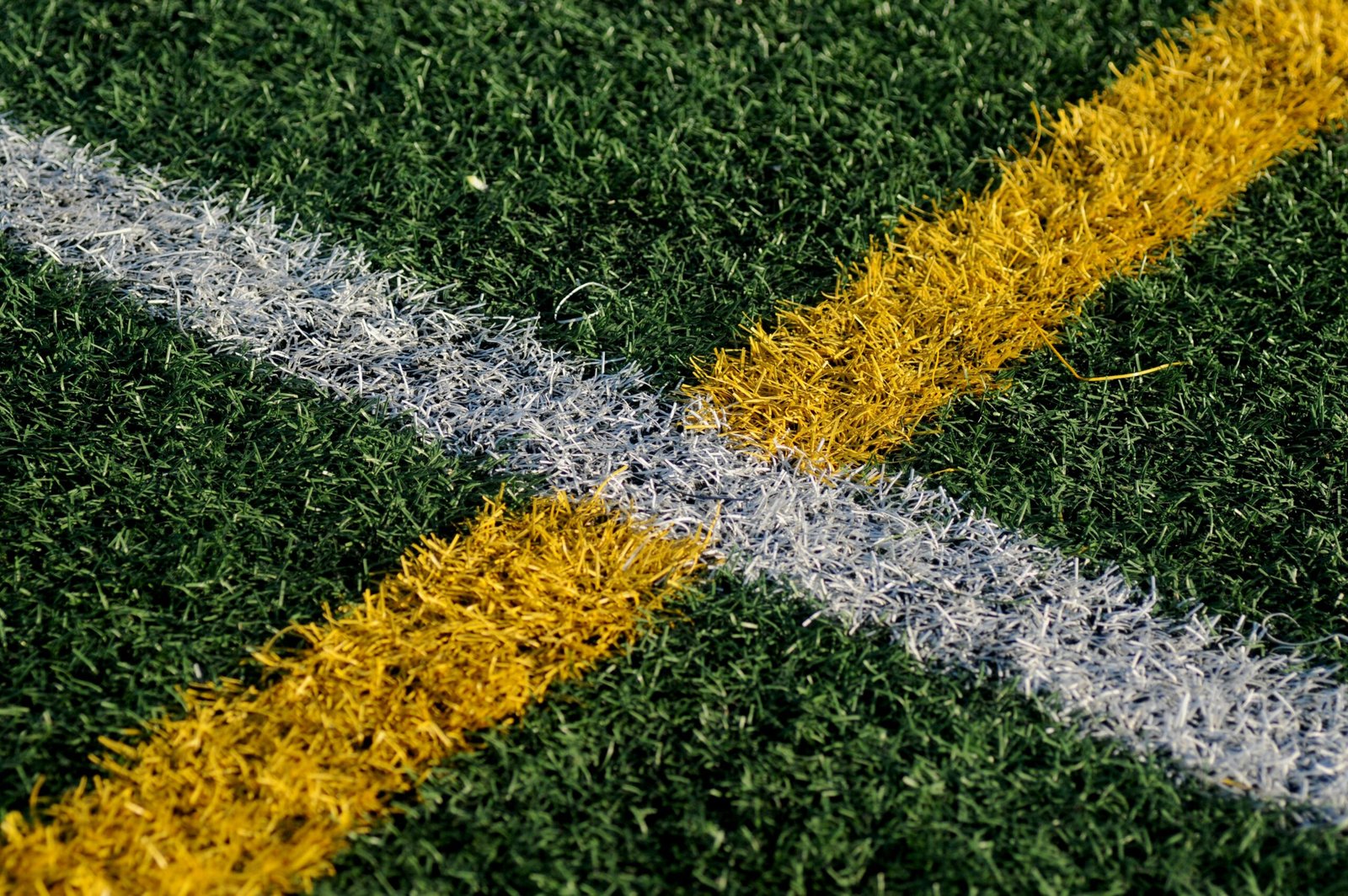 Close-up of synthetic turf with white and yellow field markings