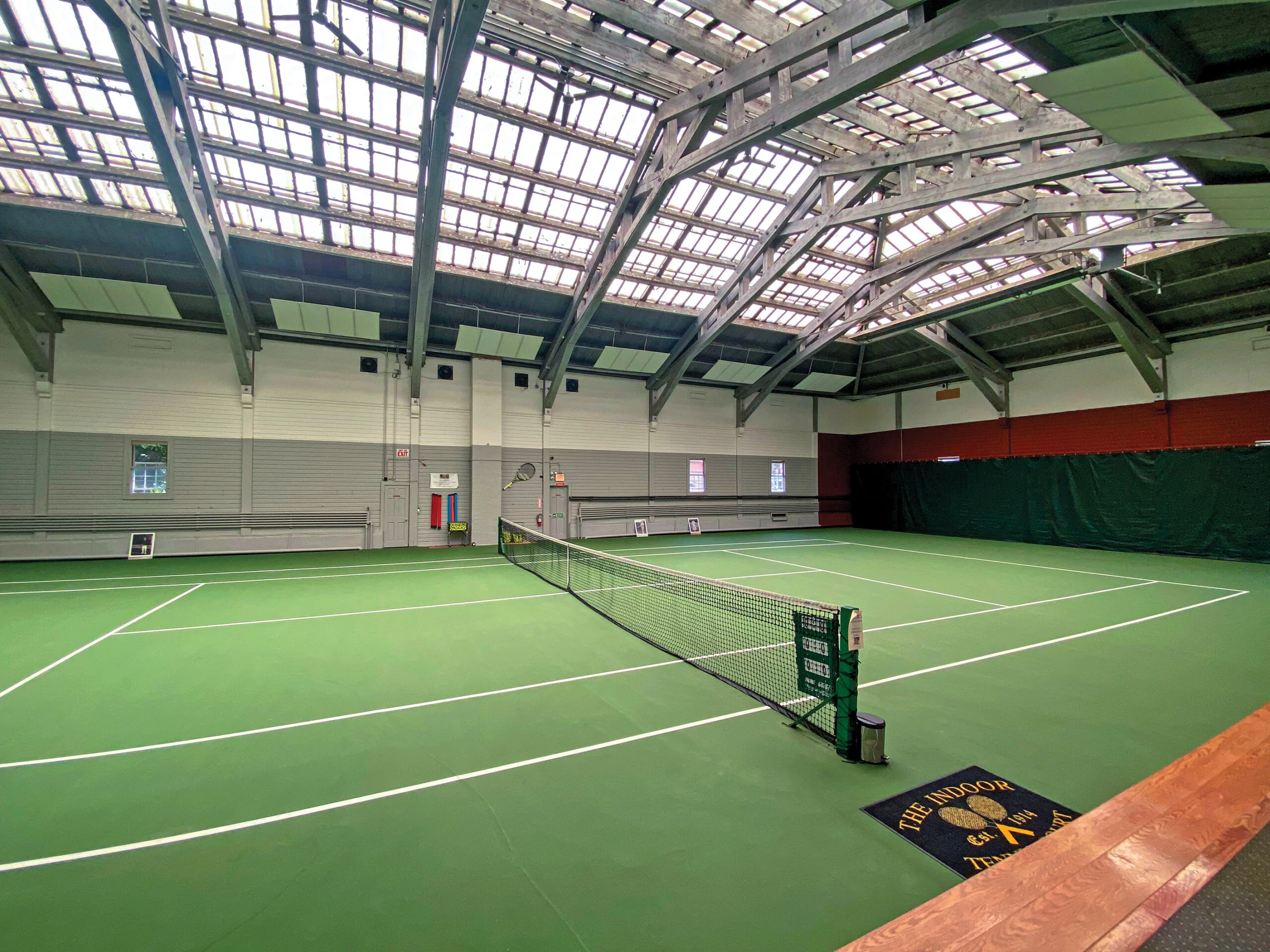 Indoor tennis court with professional sports flooring and net setup
