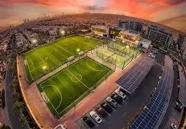 Finished sports ground with artificial turf installed and complete stadium infrastructure ready for use