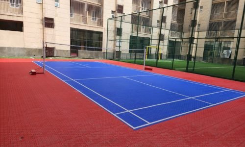 Outdoor badminton court with acrylic flooring and net installation