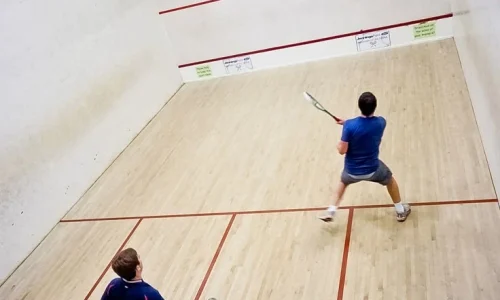 Professional indoor squash court with wooden sports flooring and glass back wall in India