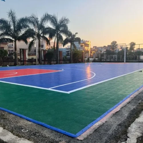 Synthetic outdoor basketball court with colorful flooring and sunset view