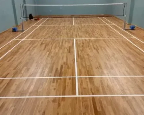 Indoor wooden badminton court flooring in Dehradun with polished surface, professional markings, and high-performance sports flooring by Y NextGen Private Limited