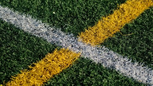 Close-up of synthetic turf with white and yellow field markings