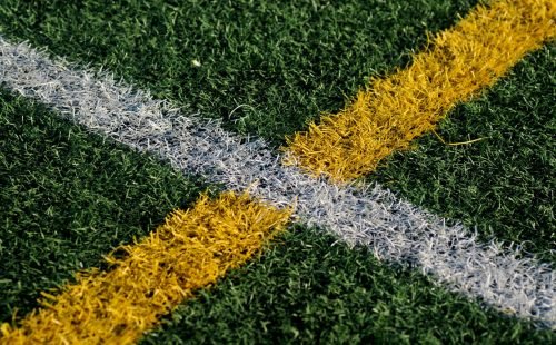 Close-up of synthetic turf with white and yellow field markings