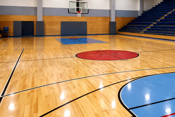 Indoor wooden basketball court with polished flooring and hoop setup